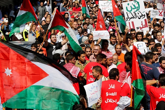 Crowd of dozens carry Jordanian flags, banners 