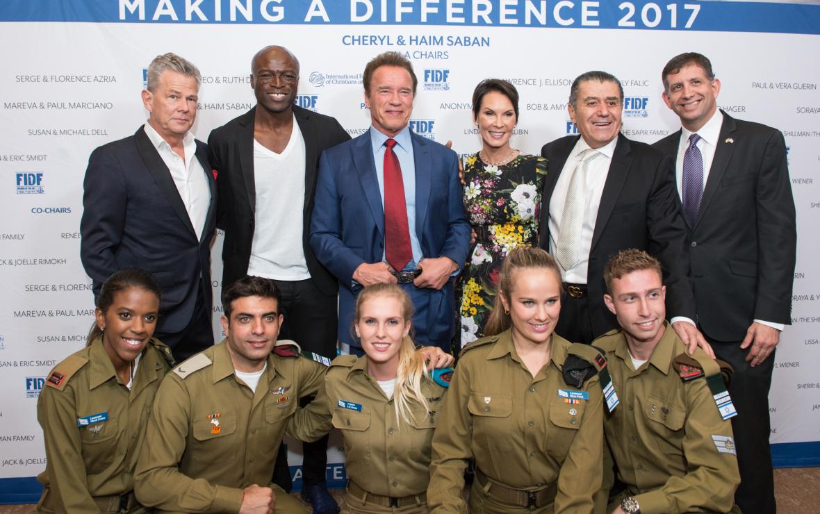 Arnold Schwarzenegger and Seal with Haim Saban posing with elements of Israel's IDF at Fundraiser Gala, Friends of IDF-FIDF in 2017.
